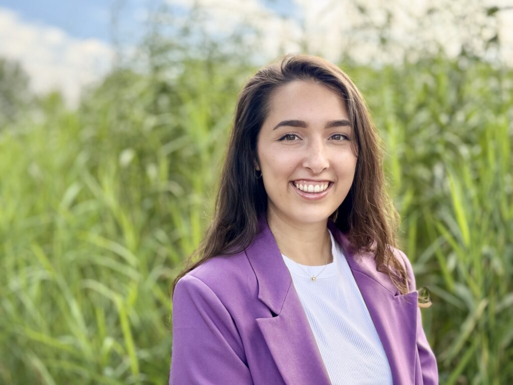 HR-professional Marloes voor een groene achtergrond